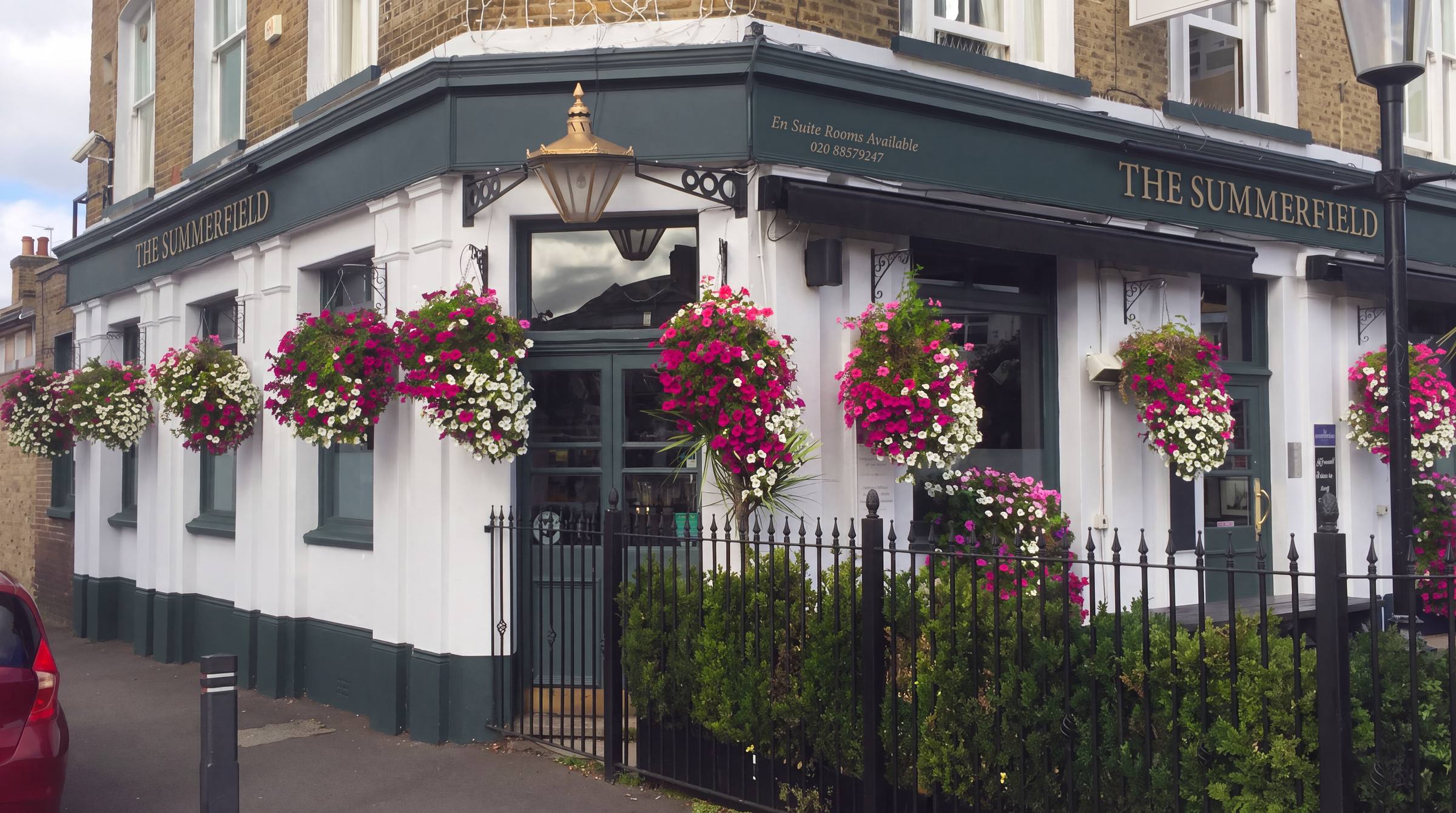 The Summerfield pub on Baring Road with its slate green frontage, gold lettering and hanging flower baskets