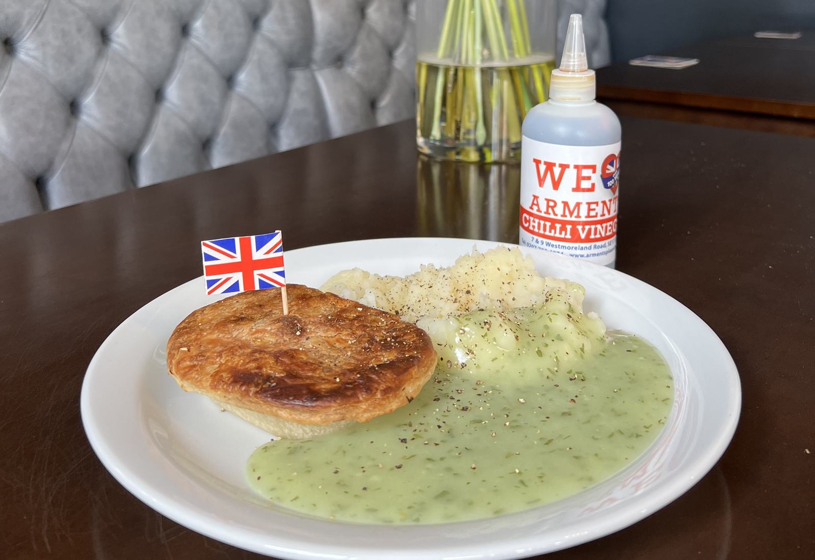 Arments pie and mash with parsley liquor, a Union Jack pick and a bottle of Arments chilli vinegar