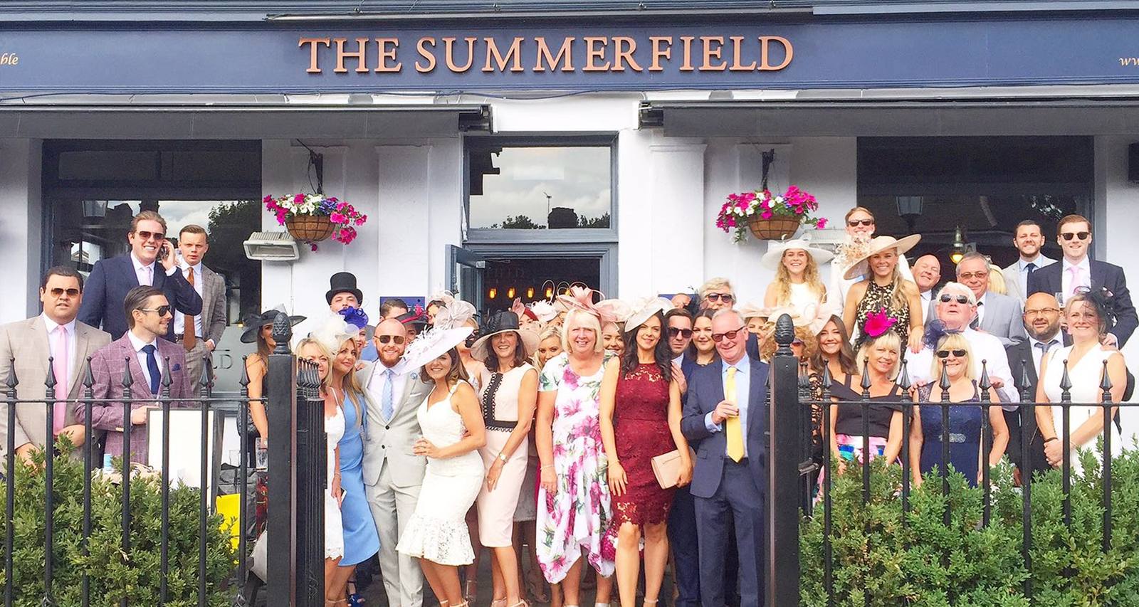 A large group dressed up for a race day outside The Summerfield